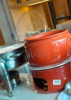 Réchaud com arroz e panelas de barro da feijoada